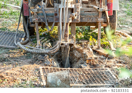 Rotary drilling rig at a construction site.Sludge flow from the joule during the water well drilling Rotary drilling rig at a construction site.Sludge flow from the joule during the water well drilling 92183331