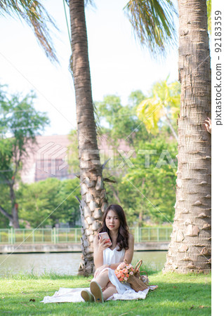 Beautiful asian women typing smartphone for social network Beautiful asian women typing smartphone for social network 92183359