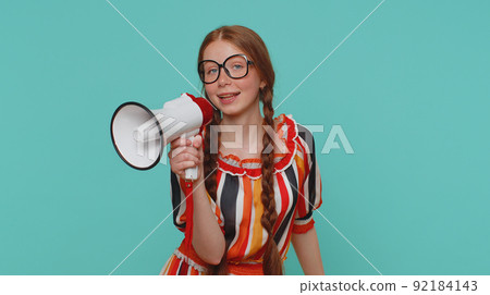 Smiling ginger girl talking with megaphone, proclaiming news, loudly announcing sale advertisement Smiling ginger girl talking with megaphone, proclaiming news, loudly announcing sale advertisement 92184143