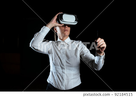 Businesswoman Wearing Virtual Reality Simulator And Holding Pen. Woman Wearing Vr Headset While Attending Professional Training Through Modern Technology. 92184515