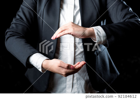 Businesswoman Holding Important Message Between Hands. Woman In Suit Showing New Crutial Idea Among Palms. Executive Presenting Updated Critical Information. Businesswoman Holding Important Message Between Hands. Woman In Suit Showing New Crutial Idea Among Palms. Executive Presenting Updated Critical Information. 92184612
