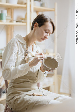 woman ceramist in the workshop makes mugs out of clay. small business or hobby is the creation of ceramic products 92185339