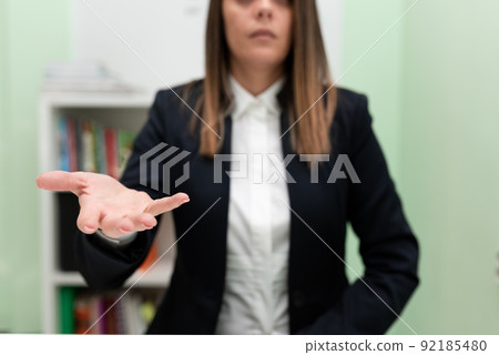 Businesswoman Holding Important Message In One Hand. Woman In Suit Showing New Crutial Idea In A Palm. Executive Presenting Updated Critical Information. Businesswoman Holding Important Message In One Hand. Woman In Suit Showing New Crutial Idea In A Palm. Executive Presenting Updated Critical Information. 92185480