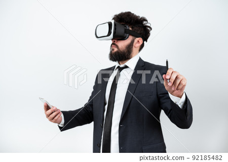 Man Holding Mobile Phone, Wearing Vr Glasses And Pointing On Recent Updates With Pen. Businessman Having Virtual Reality Eyeglasses, Cellphone And Presenting New Idea. 92185482