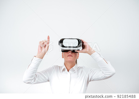 Woman Wearing Vr Glasses And Pointing On Important Messages With One Finger. Businesswoman Having Virtual Reality Eyeglasses And Showing Crutial Informations. Woman Wearing Vr Glasses And Pointing On Important Messages With One Finger. Businesswoman Having Virtual Reality Eyeglasses And Showing Crutial Informations. 92185488