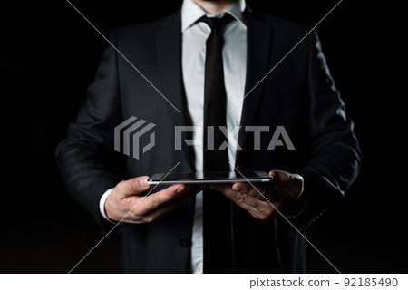 Businessman Holding Tablet With Both Hands And Presenting Important Data. Man In Suit Showing Crutial Information. Executive Displaying Crutial Announcement. Businessman Holding Tablet With Both Hands And Presenting Important Data. Man In Suit Showing Crutial Information. Executive Displaying Crutial Announcement. 92185490