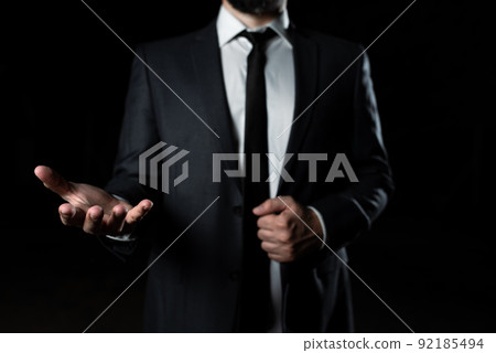 Businessman Holding Important Message In One Hand. Man In Suit Showing New Crutial Idea In A Palm. Executive Presenting Updated Critical Information. Businessman Holding Important Message In One Hand. Man In Suit Showing New Crutial Idea In A Palm. Executive Presenting Updated Critical Information. 92185494