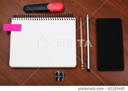 Notebook With Important Message On Desk With Pen, Pencil, Sharpener, Marker And Cellphone. Notepad With Crutial Information On Table With Mobile Phone. Notebook With Important Message On Desk With Pen, Pencil, Sharpener, Marker And Cellphone. Notepad With Crutial Information On Table With Mobile Phone. 92185495