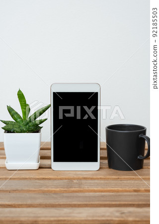 Tablet With Important Informations On Table With Plant And Cup Of Coffee. Crutial Announcements Presented On Cellphone Screen On Desk With Flower And Mug. Tablet With Important Informations On Table With Plant And Cup Of Coffee. Crutial Announcements Presented On Cellphone Screen On Desk With Flower And Mug. 92185503