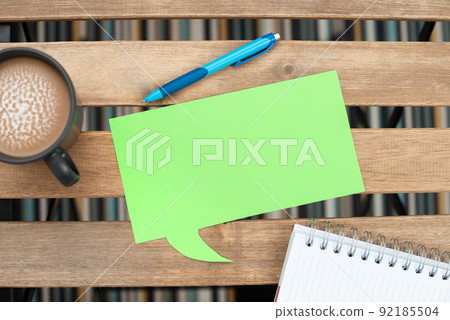 Speech Bubble With Important Message On Table With Coffee, Pen And Opened Notebook. Dialogue Balloon With Crutial Information On Desk With Cup And Ball Point. 92185504