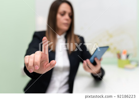 Businesswoman Holding Tablet With One Hand And Pointing Important Ideas With One Finger. Woman With Phone Showing Recent Updates. Executive Displaying Late News. 92186223