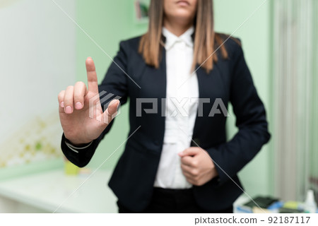 Businesswoman Pointing With One Finger On Important Messages. Executive In Suit Presenting Crutial Informations. Woman Showing Critical Announcements. Businesswoman Pointing With One Finger On Important Messages. Executive In Suit Presenting Crutial Informations. Woman Showing Critical Announcements. 92187117