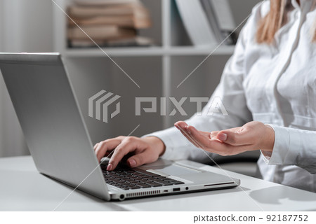 Businesswoman Typing Recent Update On Lap Top Keyboard On Desk And Holding Important Ideas Over Hand. Woman In Office Writing Late Message On Computer And Showing News. 92187752