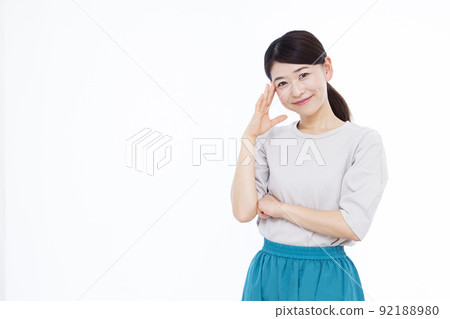 A woman in her thirties thinking with a smile 92188980