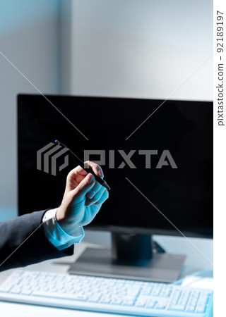 Businesswoman Holding Pen And Pointing On Important Messages On Table With Computer And Keyboard. Woman Presenting Crutial Information With One Hand. 92189197