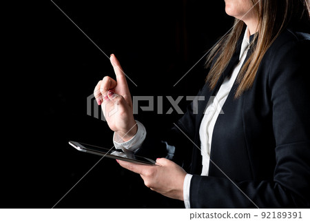 Businesswoman Holding Tablet And Pointing With One Finger On Important Message. Executive In Suit Presenting Crutial Information. Woman Showing Critical Announcement. 92189391