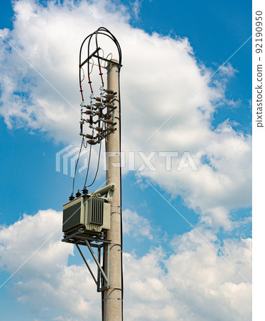 A small electric transformer mounted on a special support against the sky 92190950