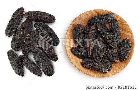Tonka bean in wooden bowl isolated on white background with full depth of field. Bean of Dipteryx odorata. Top view. Flat lay 92191613