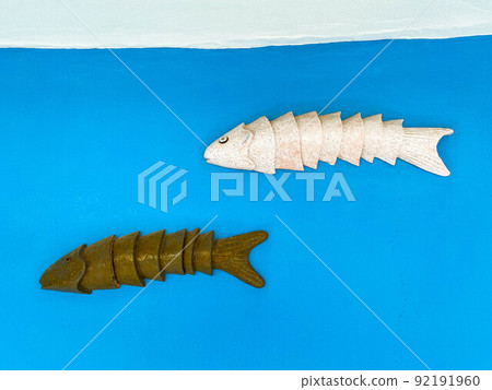 sea fish made of metal and iron. application, white and brown rubber fish. bait for fishing, fish on a blue matte background sea fish made of metal and iron. application, white and brown rubber fish. bait for fishing, fish on a blue matte background 92191960