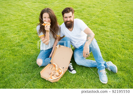 They are sharing pizza and eating. couple in love dating. They are sharing pizza and eating. couple in love dating. 92195550