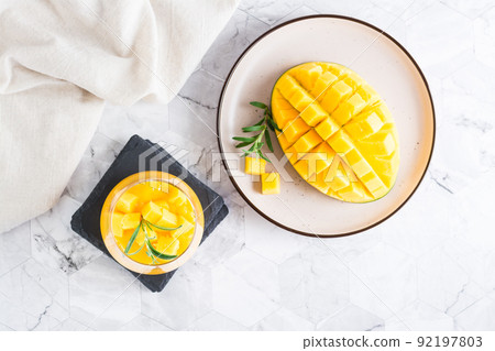 Smoothies from fresh ripe mango in glasses on the table. Homemade Dessert. Top view 92197803