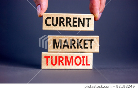 Current market turmoil symbol. Concept words Current market turmoil on wooden blocks on a beautiful grey table grey background. Businessman hand. Business, finacial current market turmoil concept. Current market turmoil symbol. Concept words Current market turmoil on wooden blocks on a beautiful grey table grey background. Businessman hand. Business, finacial current market turmoil concept. 92198249