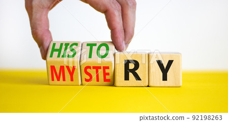 History versus mystery symbol. Concept words History and mystery on wooden cubes. Businessman hand. Beautiful yellow table white background. Business, History versus mystery concept. Copy space. History versus mystery symbol. Concept words History and mystery on wooden cubes. Businessman hand. Beautiful yellow table white background. Business, History versus mystery concept. Copy space. 92198263