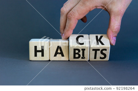 Hack habits symbol. Doctor turns wooden cubes with words 'Hack habits'. Beautiful grey table, grey background. Psychology, hack habits concept. Copy space. 92198264