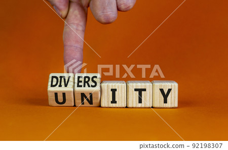 Diversity and unity symbol. Businessman turns wooden cubes and changes the word Unity to Diversity. Beautiful orange table, orange background, copy space. Business, diversity and unity concept. Diversity and unity symbol. Businessman turns wooden cubes and changes the word Unity to Diversity. Beautiful orange table, orange background, copy space. Business, diversity and unity concept. 92198307