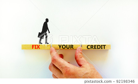 Fix your credit symbol. Concept words Fix your credit on wooden blocks on a beautiful white table white background. Businessman hand. Business, finacial and fix your credit concept. Copy space. 92198346