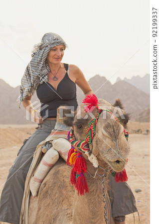 Tourist woman is sitting on a camel in Egypt. Tourist woman is sitting on a camel in Egypt. 92199337