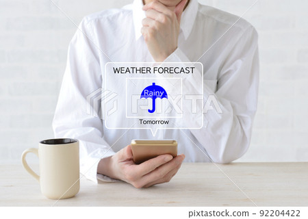 一個女人在她的智能手機雨中查看天氣預報 92204422