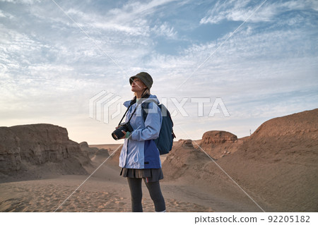 asian woman female photographer looking at landscape in gobi desert with yardang landforms asian woman female photographer looking at landscape in gobi desert with yardang landforms 92205182