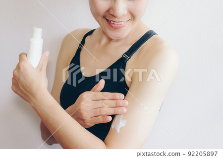 Portrait of young Asian woman applying sunscreen lotion on her body for protect her skin. 92205897