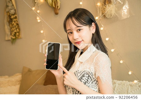Night work woman operating a smartphone 92206456