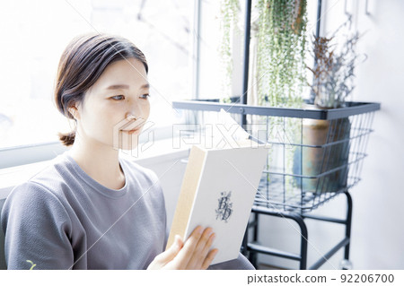 Japanese woman reading in a bright room 92206700