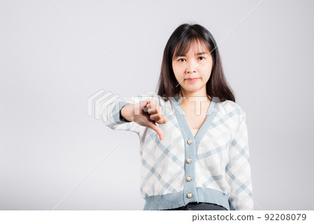 Unhappy woman smile show finger thumbs down rejection unlike Unhappy woman smile show finger thumbs down rejection unlike 92208079