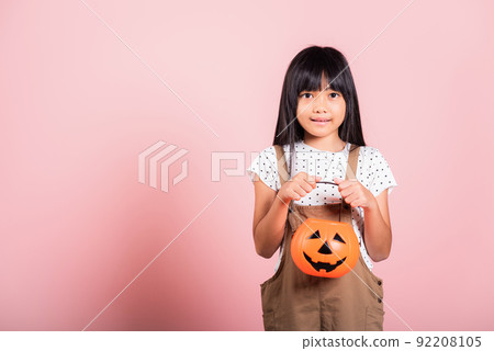 Asian little kid 10 years old holding carved Halloween pumpkin Asian little kid 10 years old holding carved Halloween pumpkin 92208105