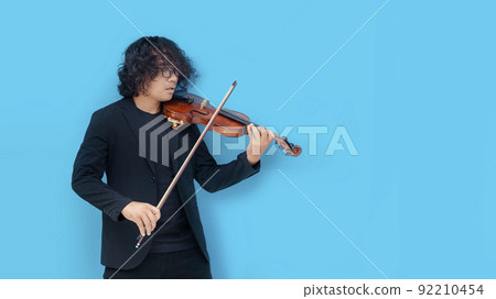 Violinist asian man play wood violin on blue isolated background 92210454