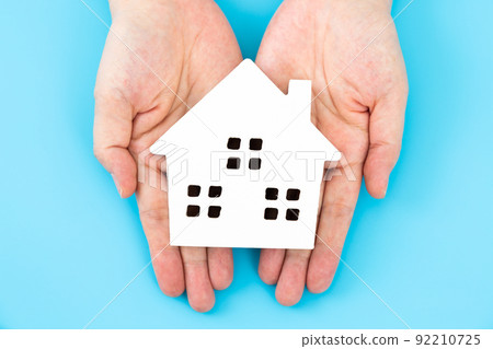 Hand of a middle woman holding a house model of a house Hand of a middle woman holding a house model of a house 92210725