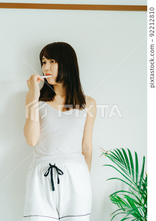 A young woman brushing teeth A young woman brushing teeth 92212810