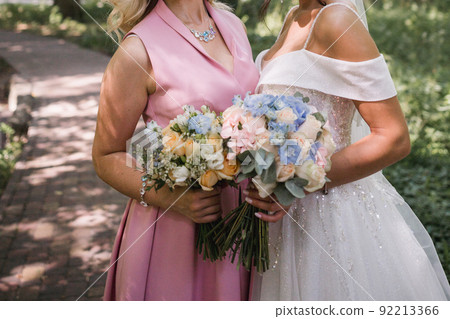 bride with girlfriend in park at wedding 92213366