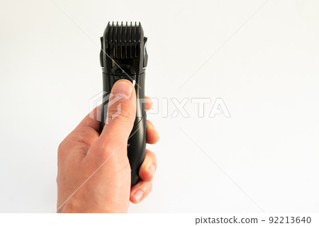 electric trimmer in a hand on a white background 92213640