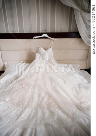 bride's wedding shoes and wedding dress on the bed bride's wedding shoes and wedding dress on the bed 92214061