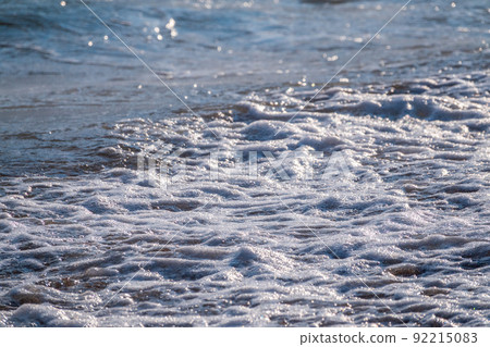 Splashes of water and foam against the sea on a sunny summer day 92215083