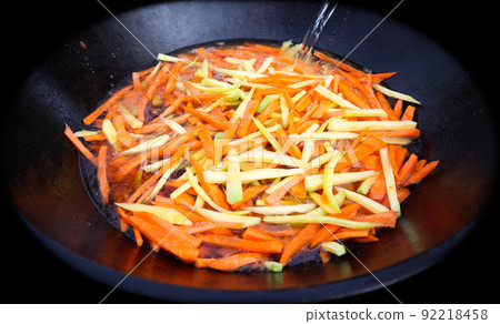 Yellow and orange carrot in cauldron. Pilaf cooking process. Yellow and orange carrot in cauldron. Pilaf cooking process. 92218458