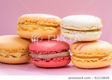 Colorful french cookies macarons set on pink background. Tasty fruit, almond sweet cookies, cake macaron. Holiday backdrop design. Colorful french cookies macarons set on pink background. Tasty fruit, almond sweet cookies, cake macaron. Holiday backdrop design. 92218609