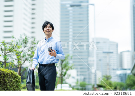 A businessman in a shirt checking the destination with a map search app A businessman in a shirt checking the destination with a map search app 92218691