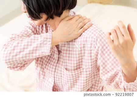 中年婦女穿著睡衣，在臥室裡肩膀僵硬 92219807