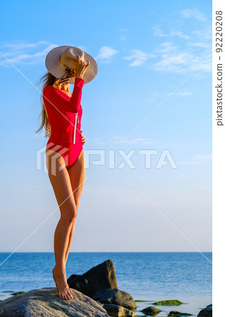 Female tourist with hat admiring sea Female tourist with hat admiring sea 92220208